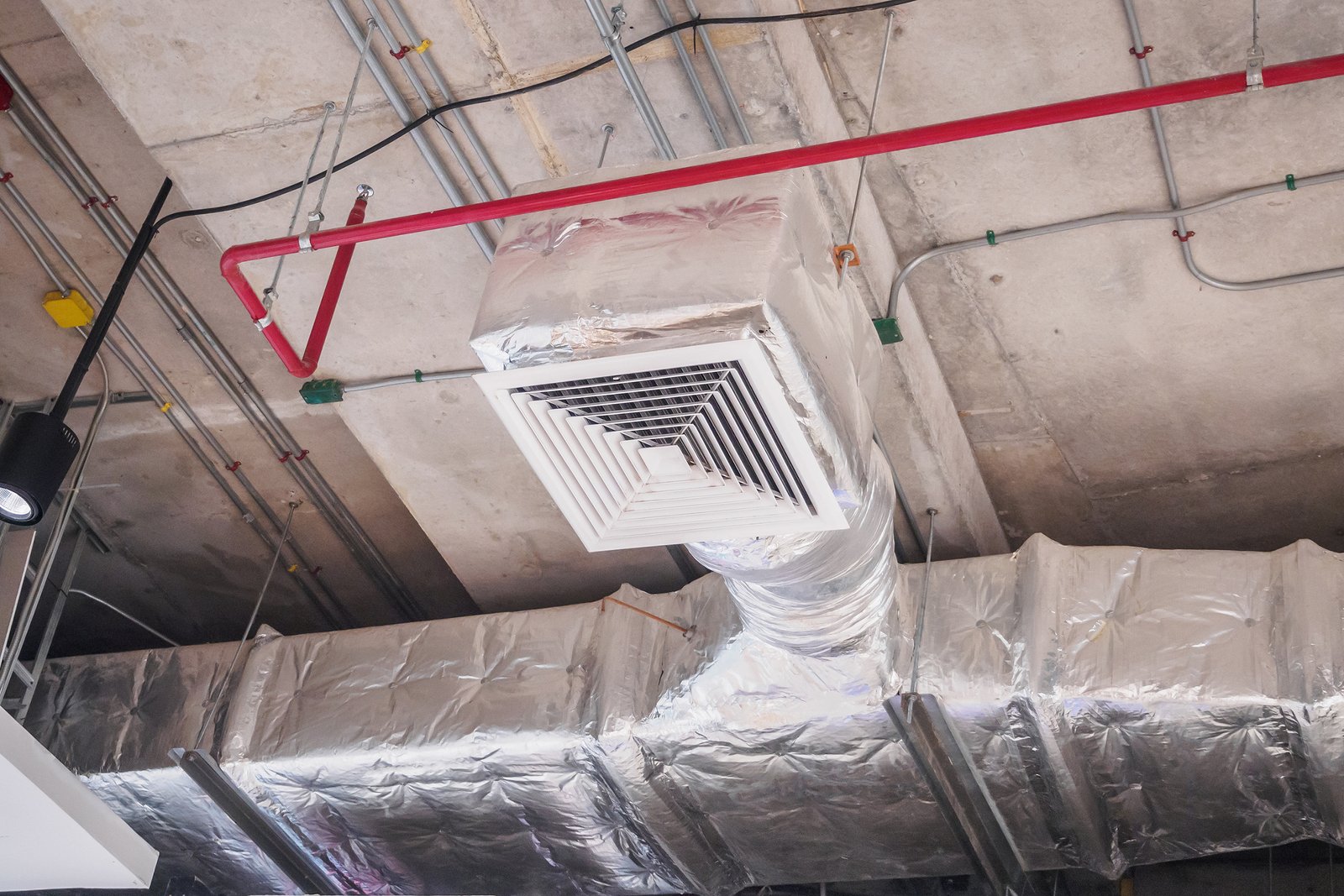 A ceiling-mounted HVAC duct system with an insulated air vent grille, designed for efficient airflow in a commercial building.