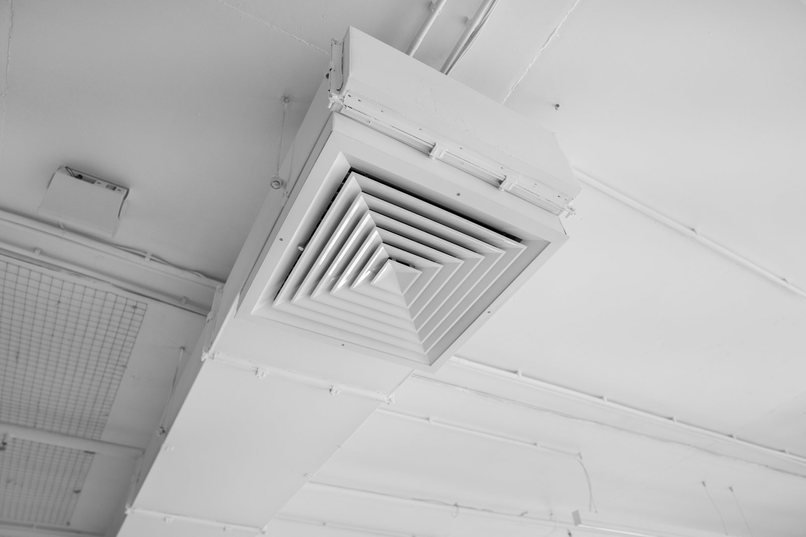 A ceiling-mounted HVAC ventilation duct with a square diffuser, designed for efficient air distribution in a commercial or office space.