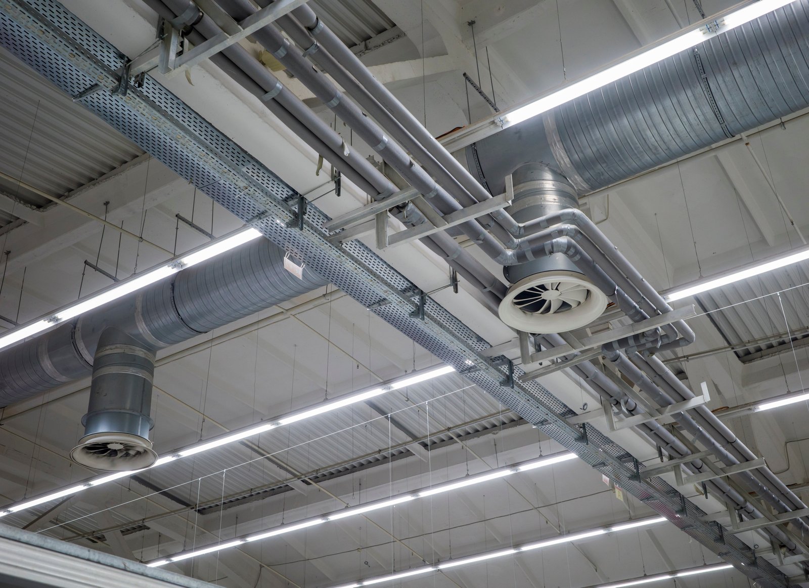 Commercial HVAC ductwork and ventilation system installed on the ceiling of a large industrial or retail building, ensuring efficient airflow and climate control.