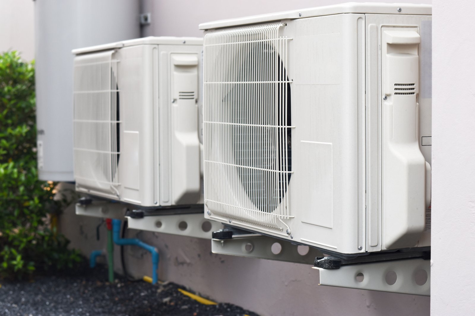 Multiple wall-mounted outdoor heat pump units installed on a building exterior, providing efficient heating and cooling.